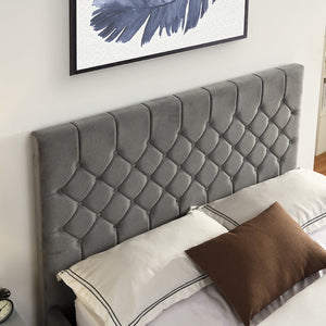 Grey tufted headboard with pillows on a bed in a bedroom setting.
