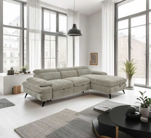 Modern living room with a gray sectional sofa, coffee table, and large windows.
