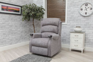 Gray recliner chair in a room with a clock, plant, and side table.