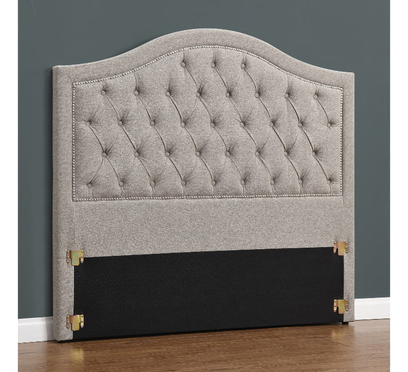 Gray tufted headboard with black base on a gray wall background