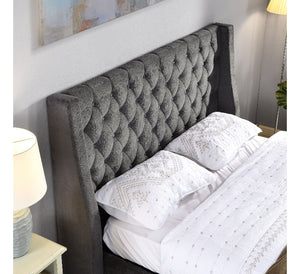 Gray tufted headboard with white bedding and pillows in a bedroom setting.