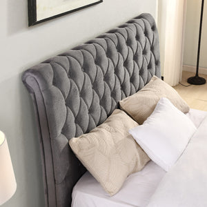 Grey tufted headboard with pillows on a bed in a bedroom setting
