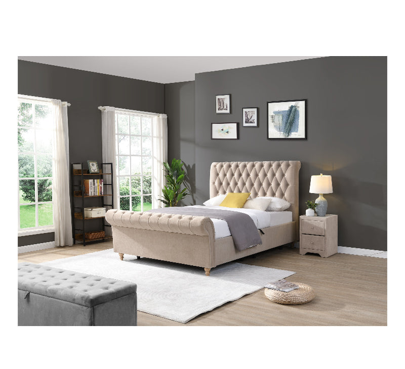 Beige upholstered bed in a bedroom with grey walls and white curtains.