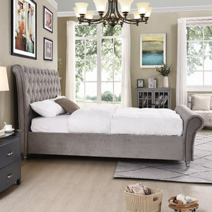 Neatly arranged bedroom with grey upholstered bed, nightstands, and decor.