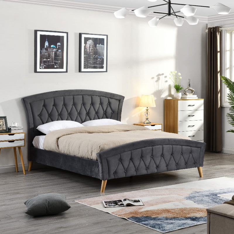 Grey upholstered bed in a bedroom setting with decor elements.