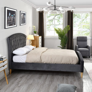 Modern bedroom with grey upholstered bed, nightstands, and armchair.
