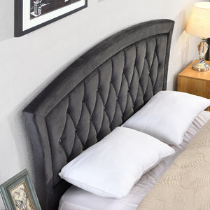 Grey tufted headboard with white pillows on a bed in a bedroom setting.