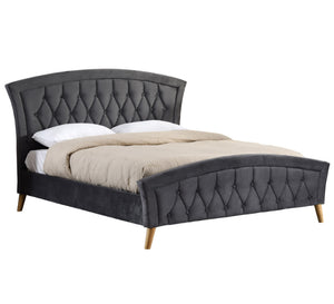 Grey upholstered bed with tufted design on a white background