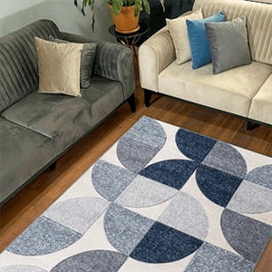 Living room with a patterned rug, gray and beige sofa, and blue cushions.