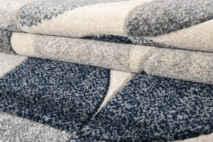 Close-up of textured fabric rolls in gray, beige, and blue.