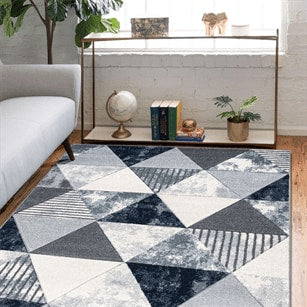 Geometric patterned rug in a living room setting with a console table and decor items.