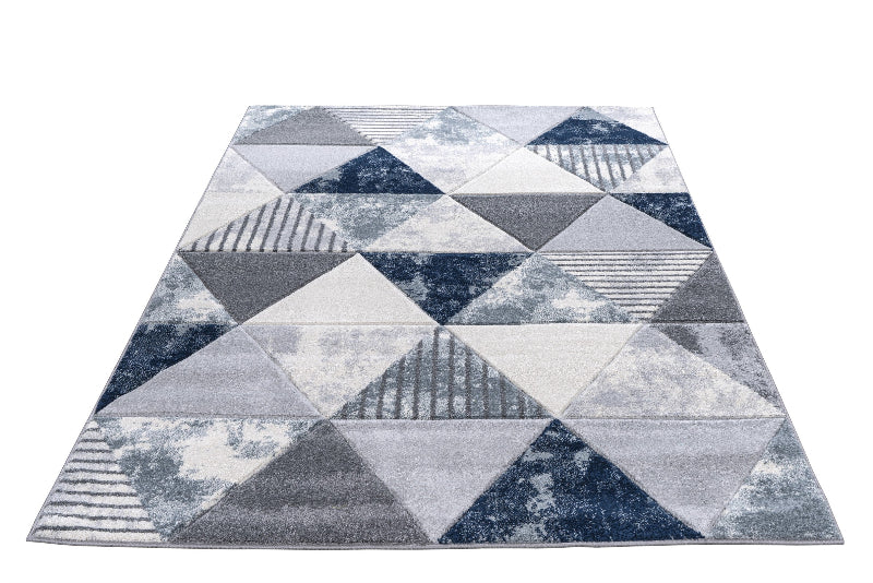 Geometric patterned rug with triangles in blue, gray, and white on a white background