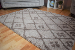 Patterned rug on a wooden floor with furniture in the background