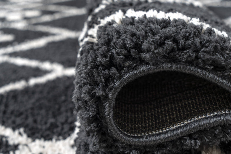 Close-up of a textured black rug with a patterned surface