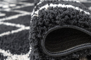 Close-up of a textured black rug with a patterned surface