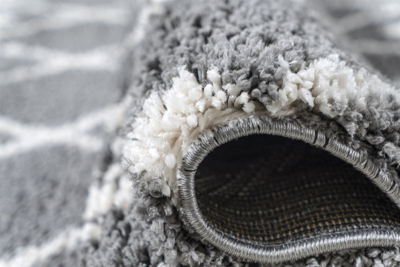 Close-up of a grey textured rug with a visible weave pattern.
