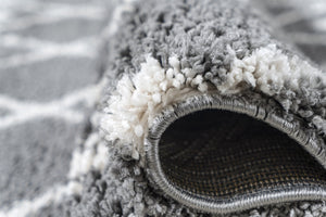 Close-up of a grey textured rug with a visible weave pattern.