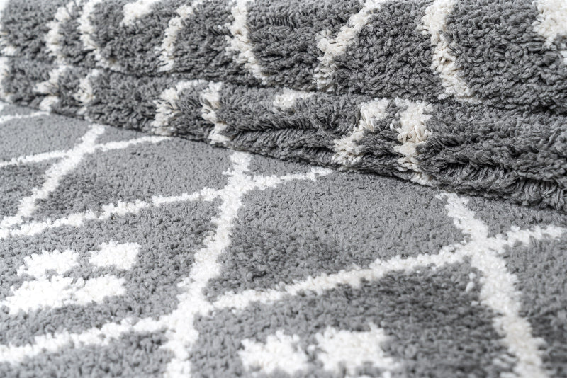 Close-up of a textured grey and white rug with geometric pattern