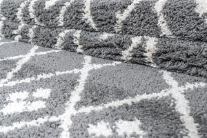 Close-up of a textured grey and white rug with geometric pattern