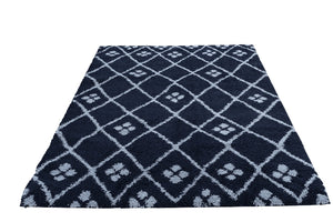 Navy blue rug with white geometric pattern on a white background