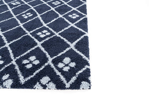 Navy blue rug with white paw print pattern on a white background