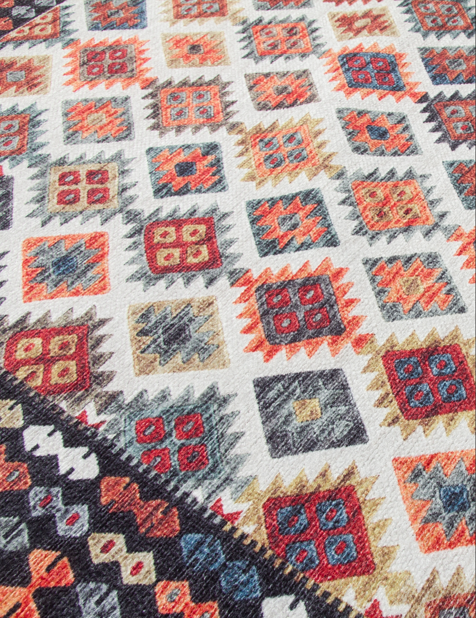 Close-up of a patterned fabric with geometric design in red, blue, and beige.