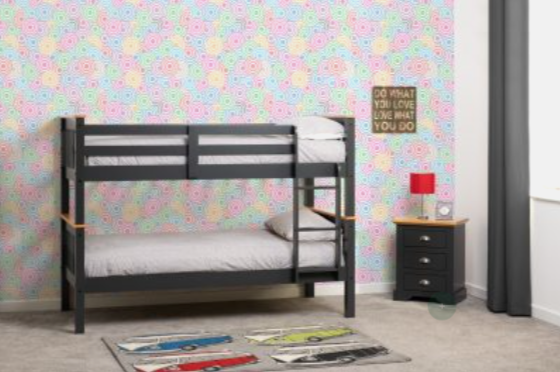 Bunk bed in a room with colorful floral wallpaper and a nightstand.