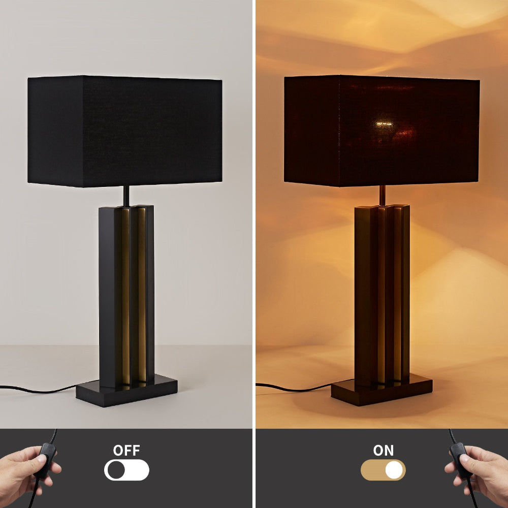 Table lamp with black shade and metallic base, shown off and on with remote control.