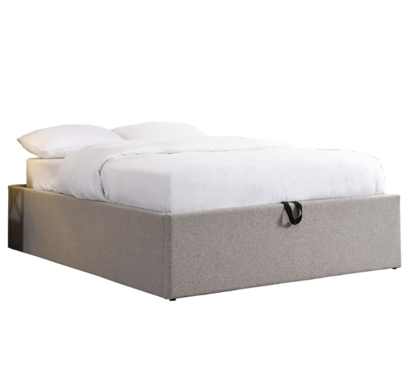 Bed with white bedding and beige frame on a white background
