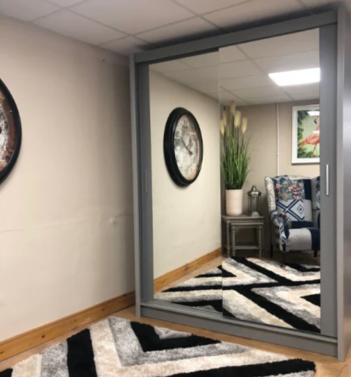 Sliding glass door with a reflective surface showing an interior room with decor elements.