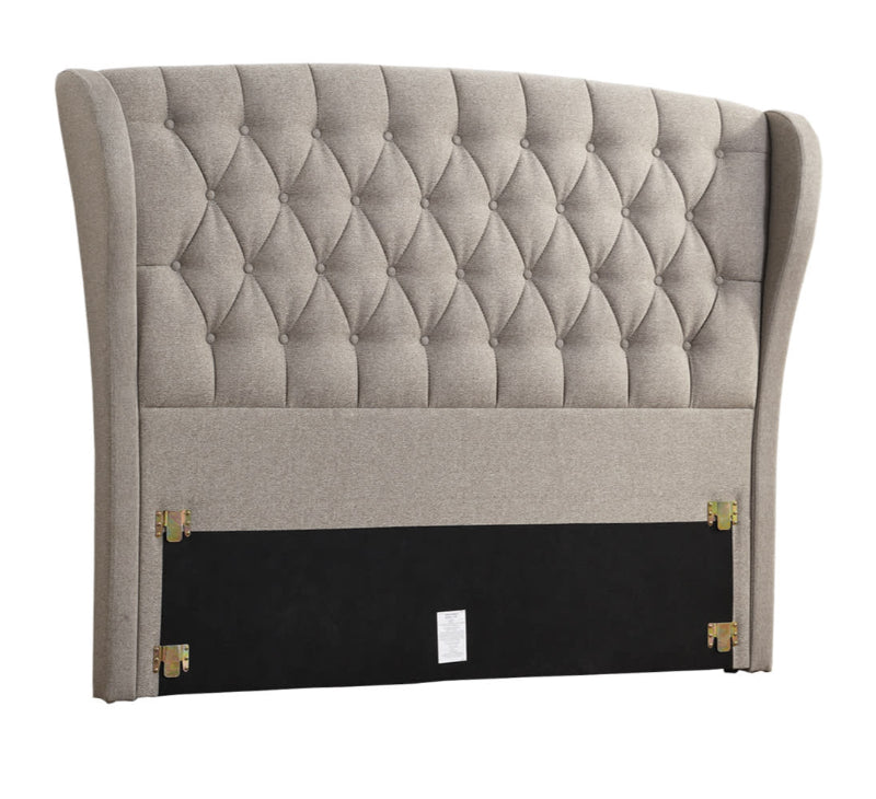 Gray tufted headboard with decorative buttons on a white background