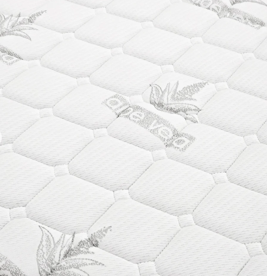 Close-up of a white quilted surface with a brand logo.