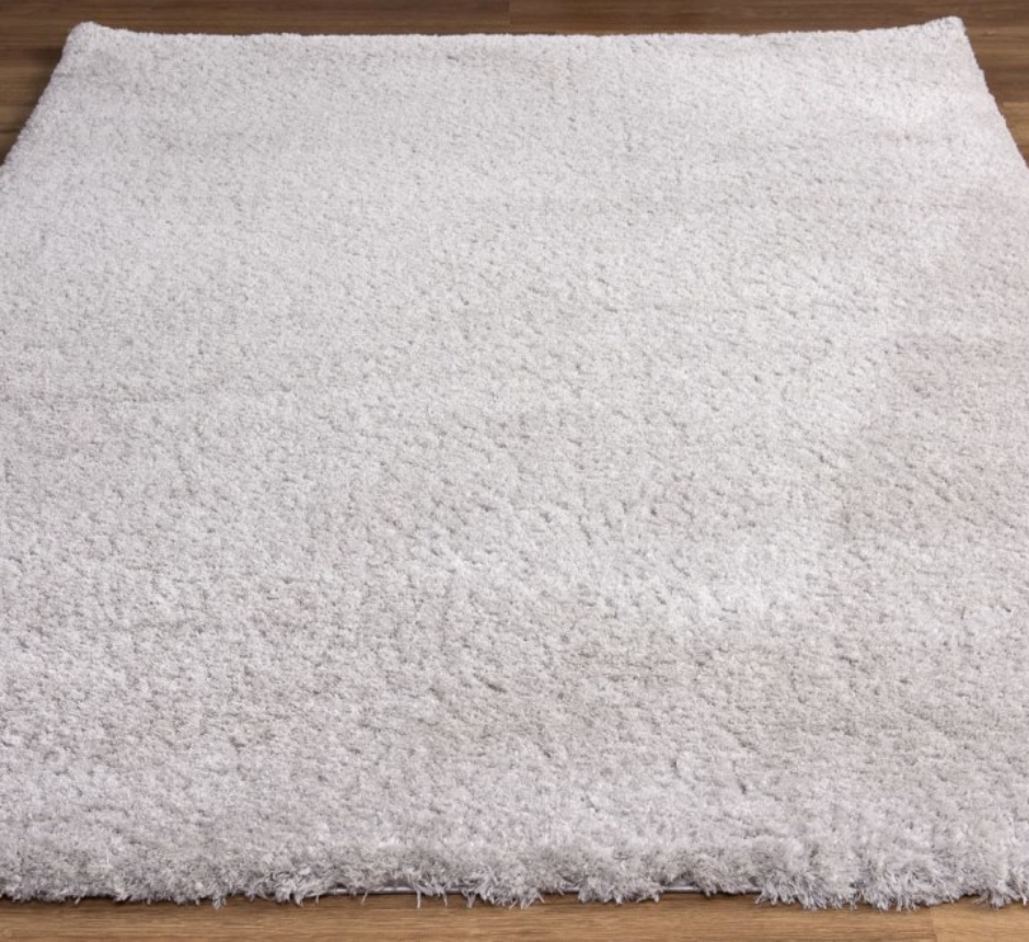 Close-up of a textured gray rug on a wooden floor