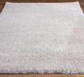 Close-up of a textured gray rug on a wooden floor