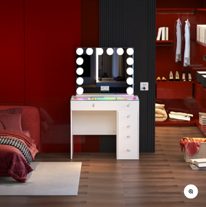 Dressing table with illuminated mirror in a room with red walls and a closet.