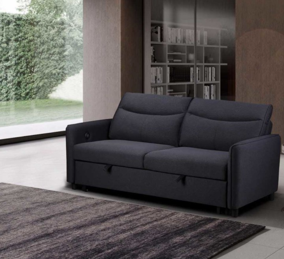 Gray sofa bed in a modern living room with a bookshelf and window.