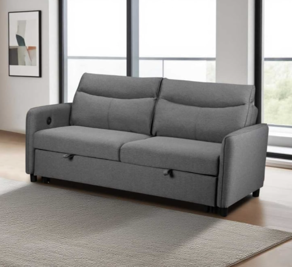 Gray sofa bed in a room with large windows and a rug.