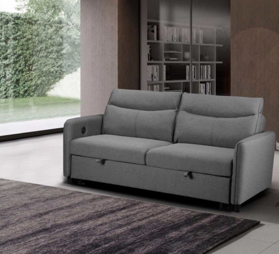 Gray sofa bed in a modern living room with a bookshelf and large window.