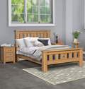 Wooden bed with bedding in a room with a window and side tables.