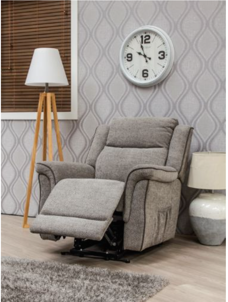 Gray recliner chair in a living room with a clock on the wall and a lamp.