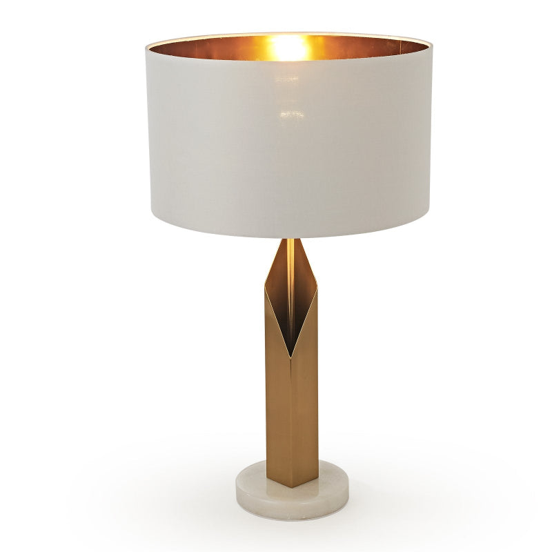 Table lamp with a gold base and white shade on a white background