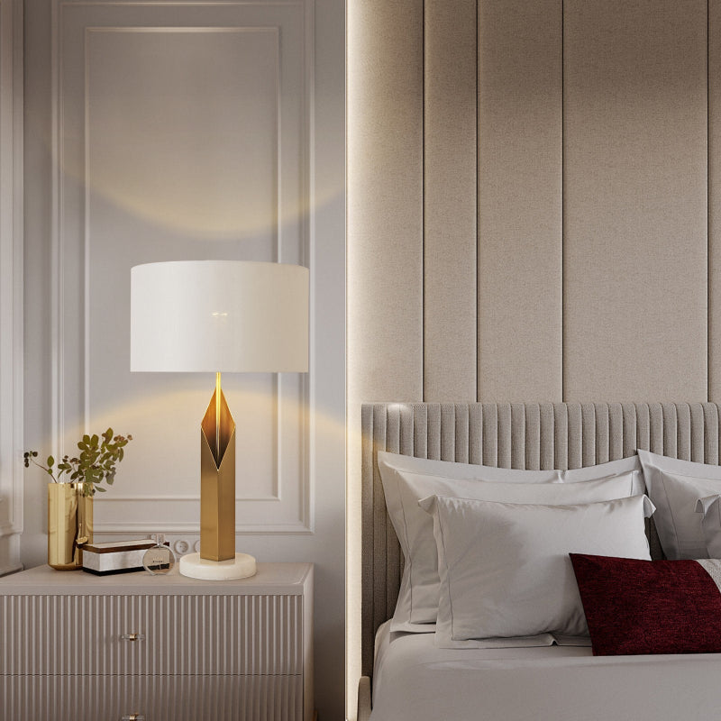 Modern bedroom with a lamp on a nightstand and a bed with pillows.
