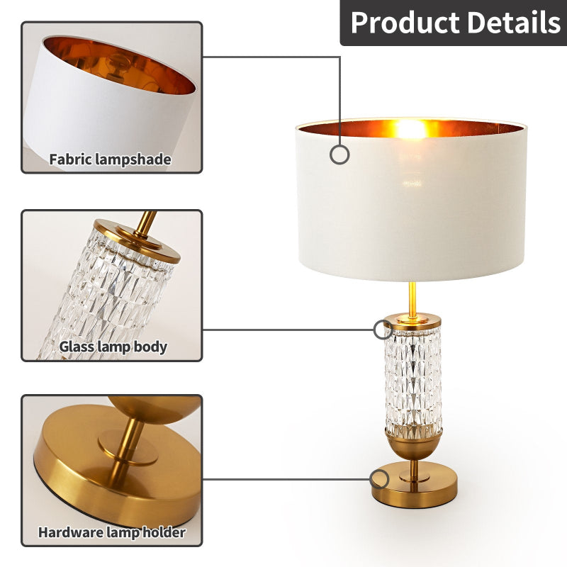 Table lamp with fabric lampshade, glass lamp body, and gold hardware on a white background.