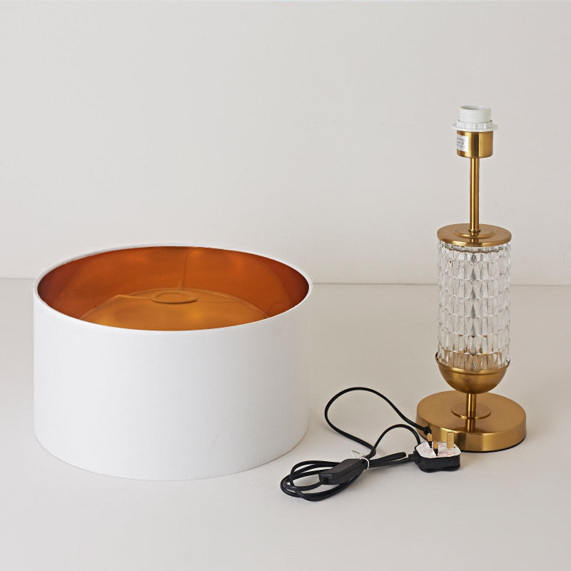 Decorative lamp with white base and gold accents on a plain background
