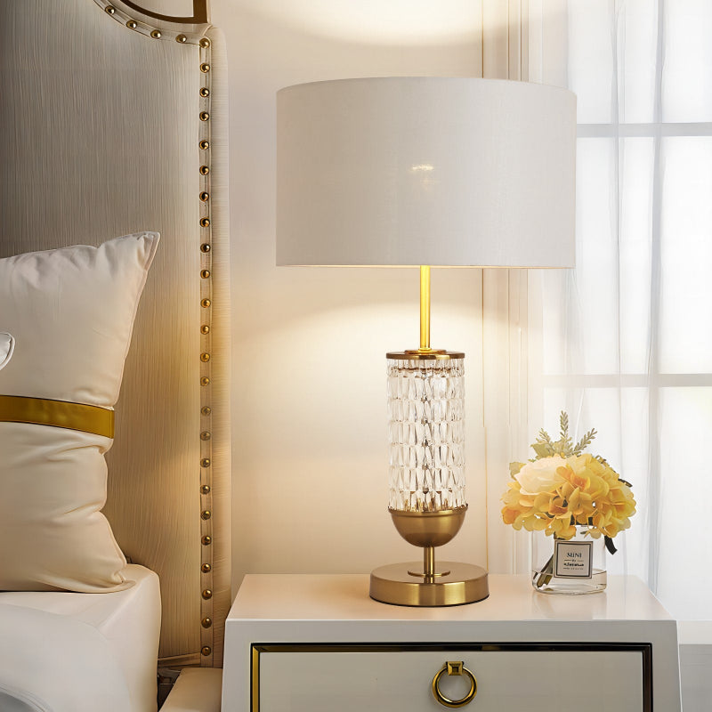 Decorative lamp on a nightstand next to a bed with pillows