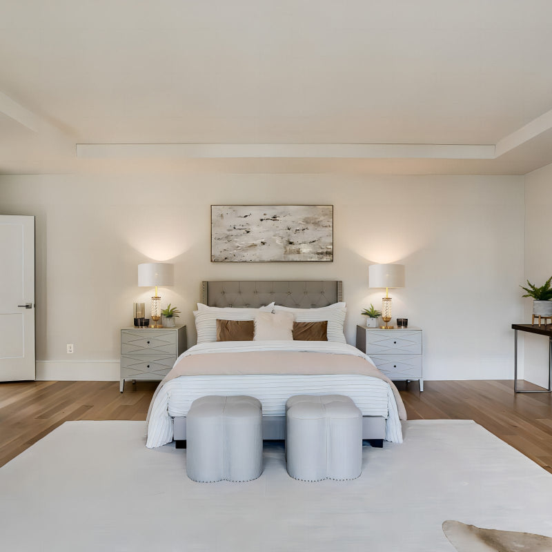 Modern bedroom with a bed, nightstands, and artwork on the wall.