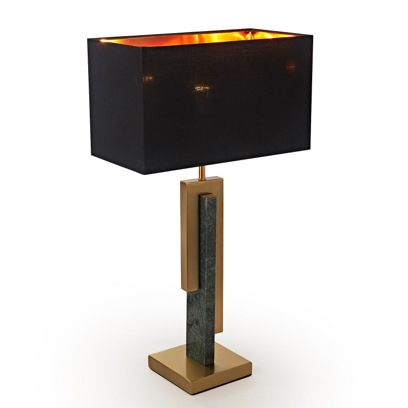 Table lamp with black shade and gold base on a white background