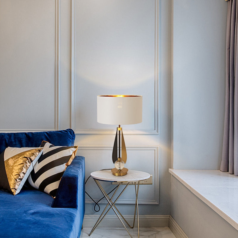 Modern living room with a blue sofa, decorative pillows, and a lamp on a small table.