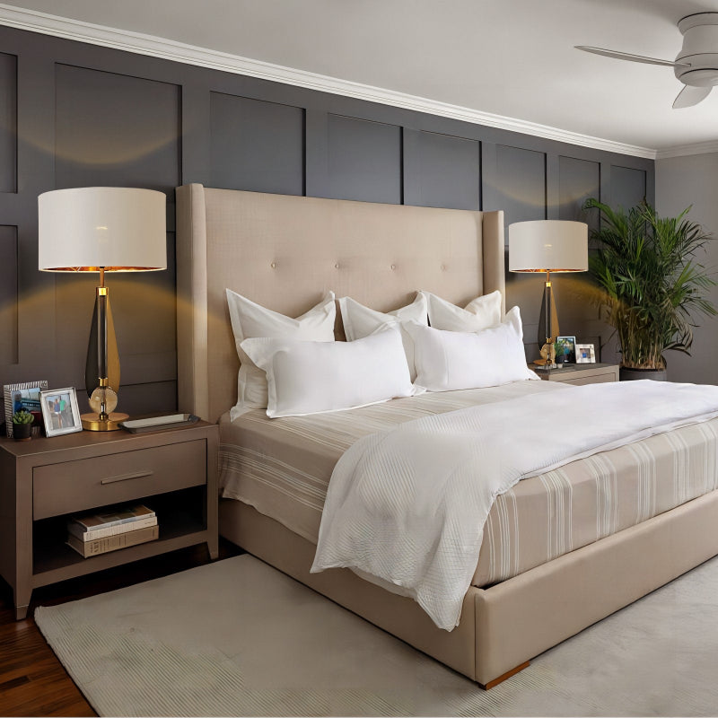 Neatly made bed with beige headboard and white bedding in a bedroom setting.