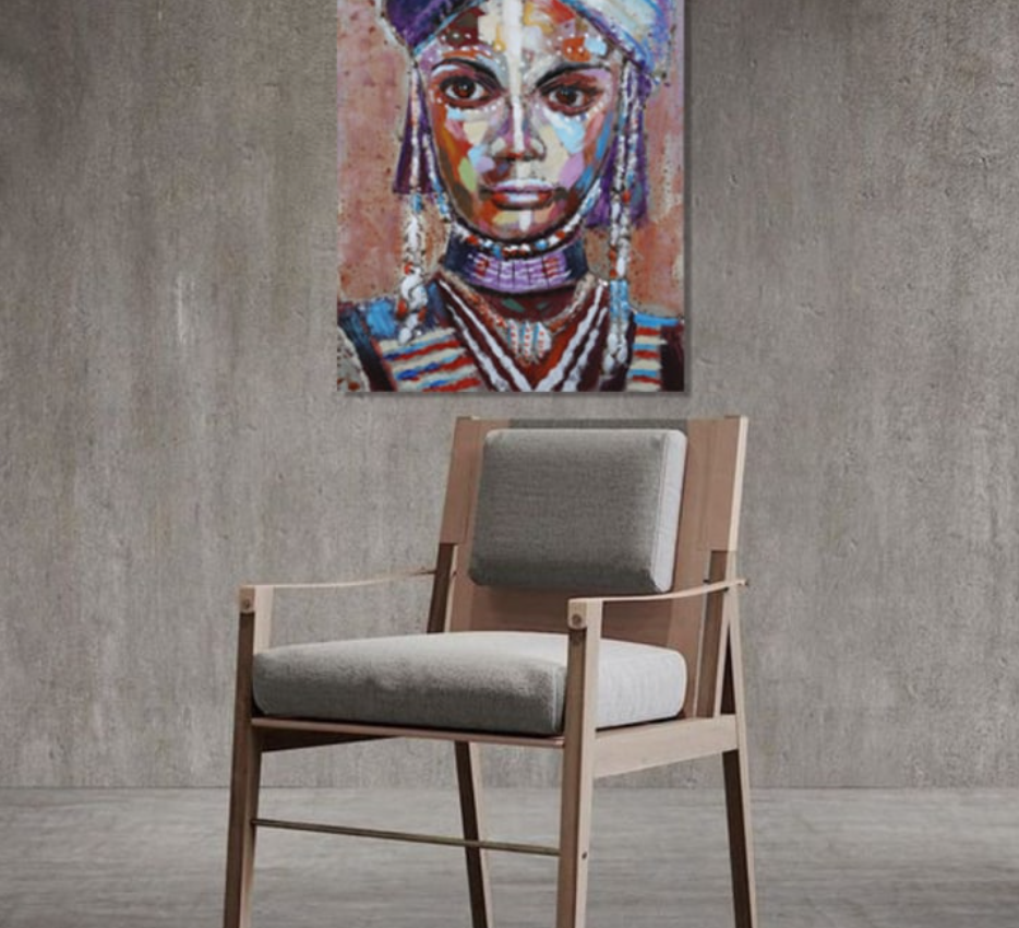 Chair with gray cushion in front of a wall with a colorful portrait of a woman.